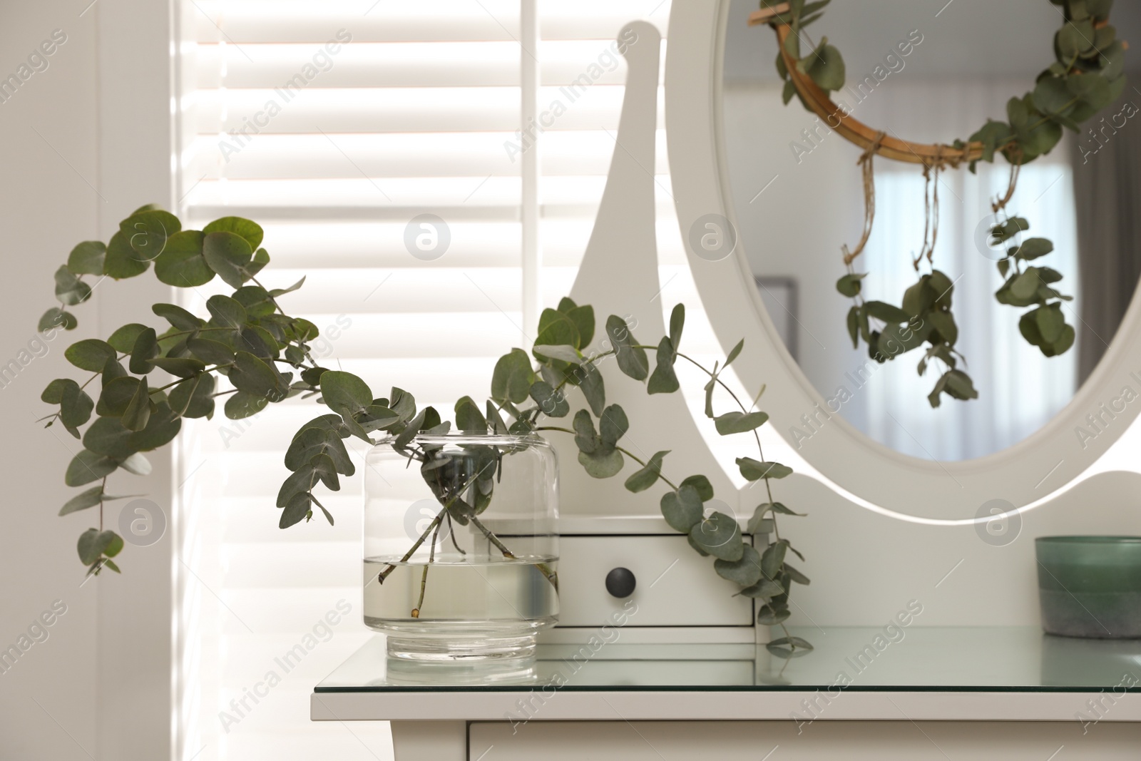 Photo of Stylish dressing table decorated with beautiful eucalyptus branches indoors