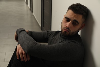 Portrait of sad young man in hall