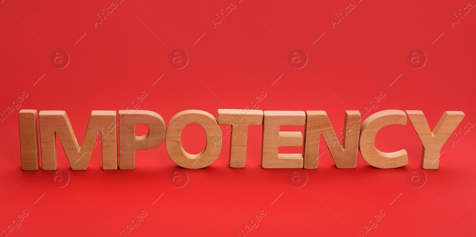 Photo of Word IMPOTENCY made of wooden letters on red background