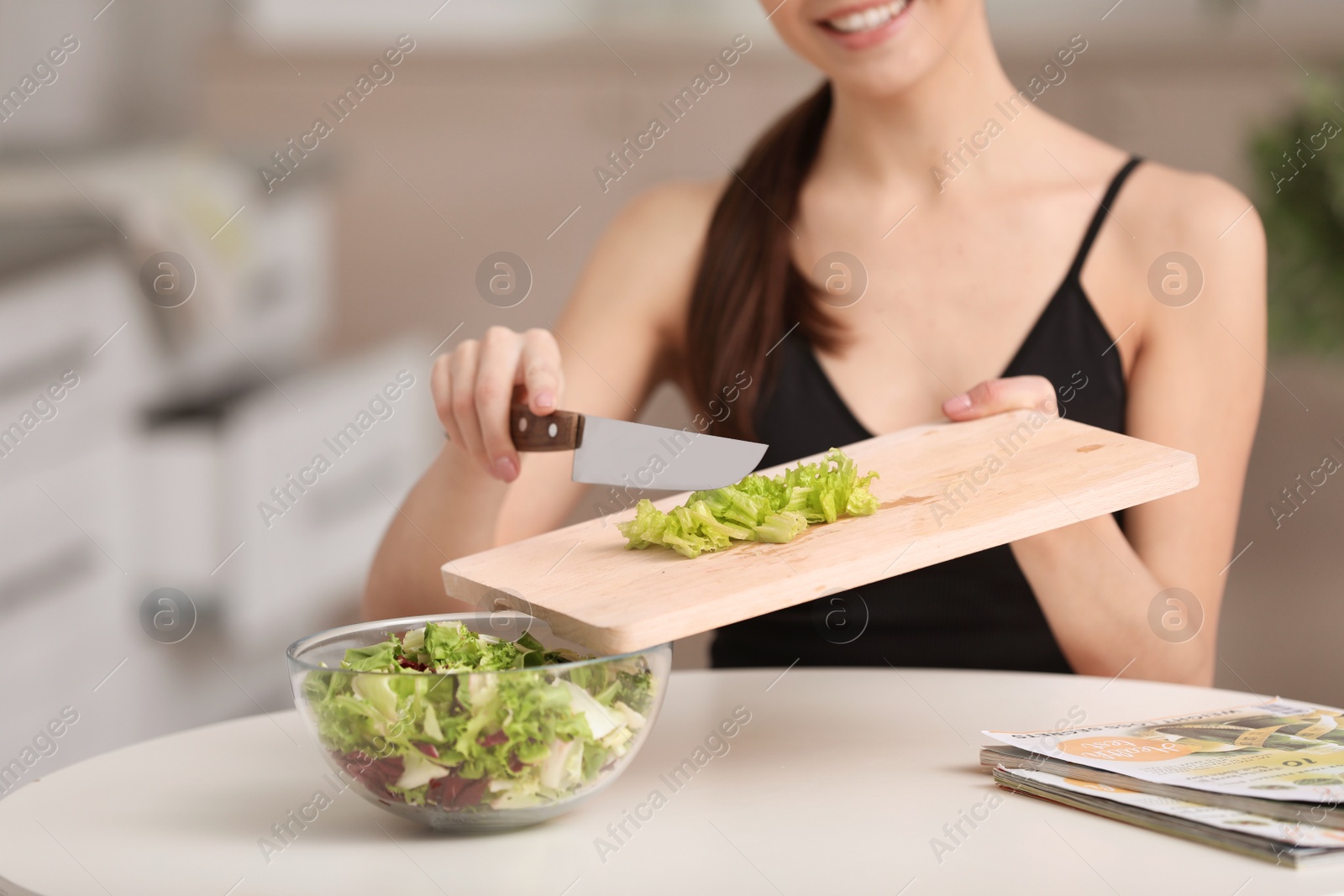 Photo of Young woman in fitness clothes preparing healthy breakfast at home, closeup