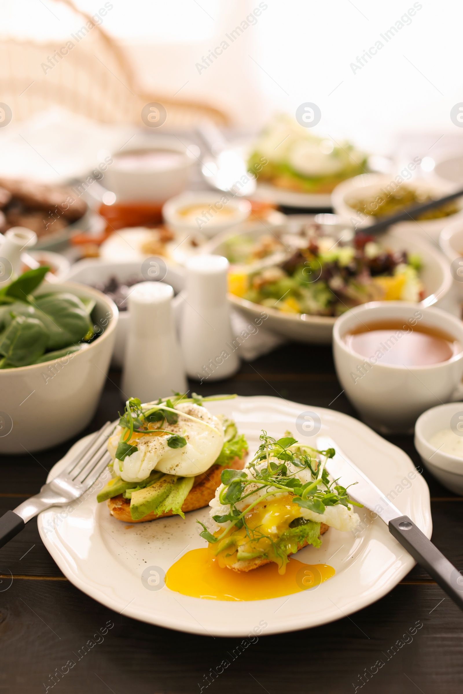 Photo of Delicious sandwiches and many different dishes served on buffet table for brunch