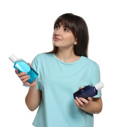 Young woman with different types of mouthwash on white background