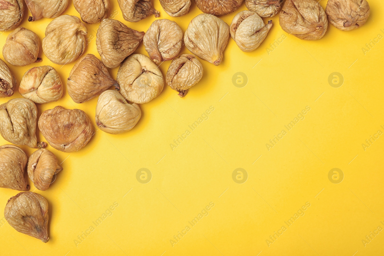 Photo of Dried figs on color background, top view with space for text. Healthy fruit