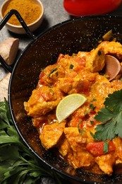 Delicious chicken curry in frying pan on table
