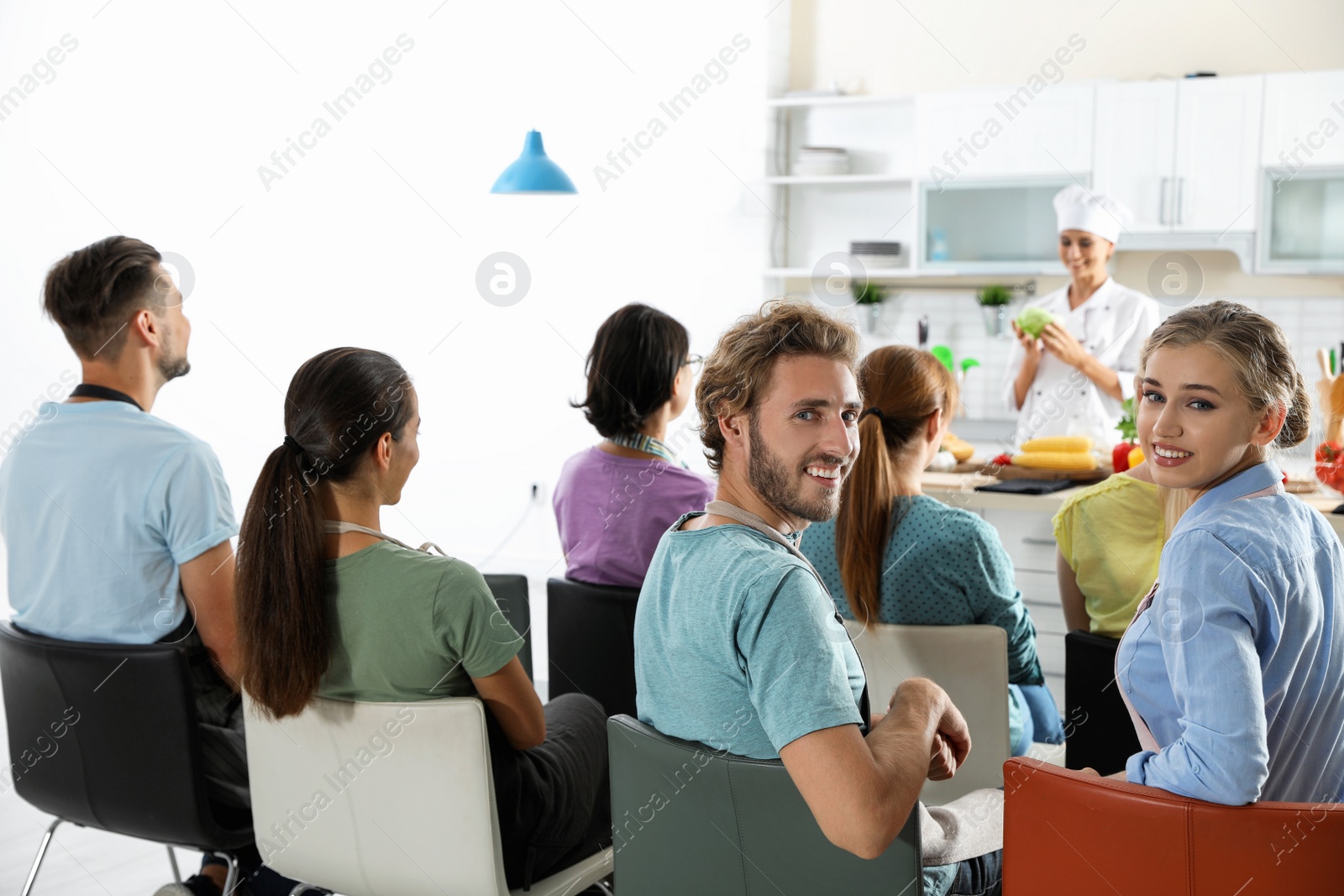 Photo of Group of people and female chef at cooking classes