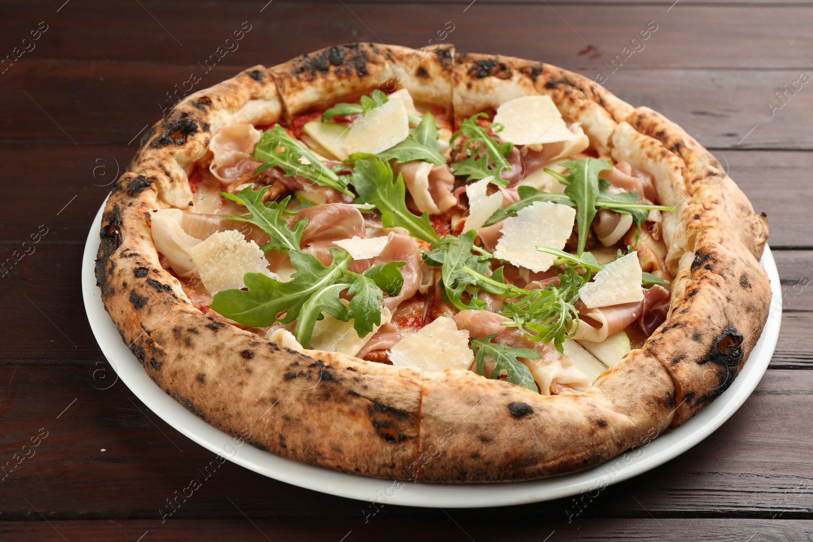 Photo of Tasty pizza with meat and arugula on wooden table, closeup