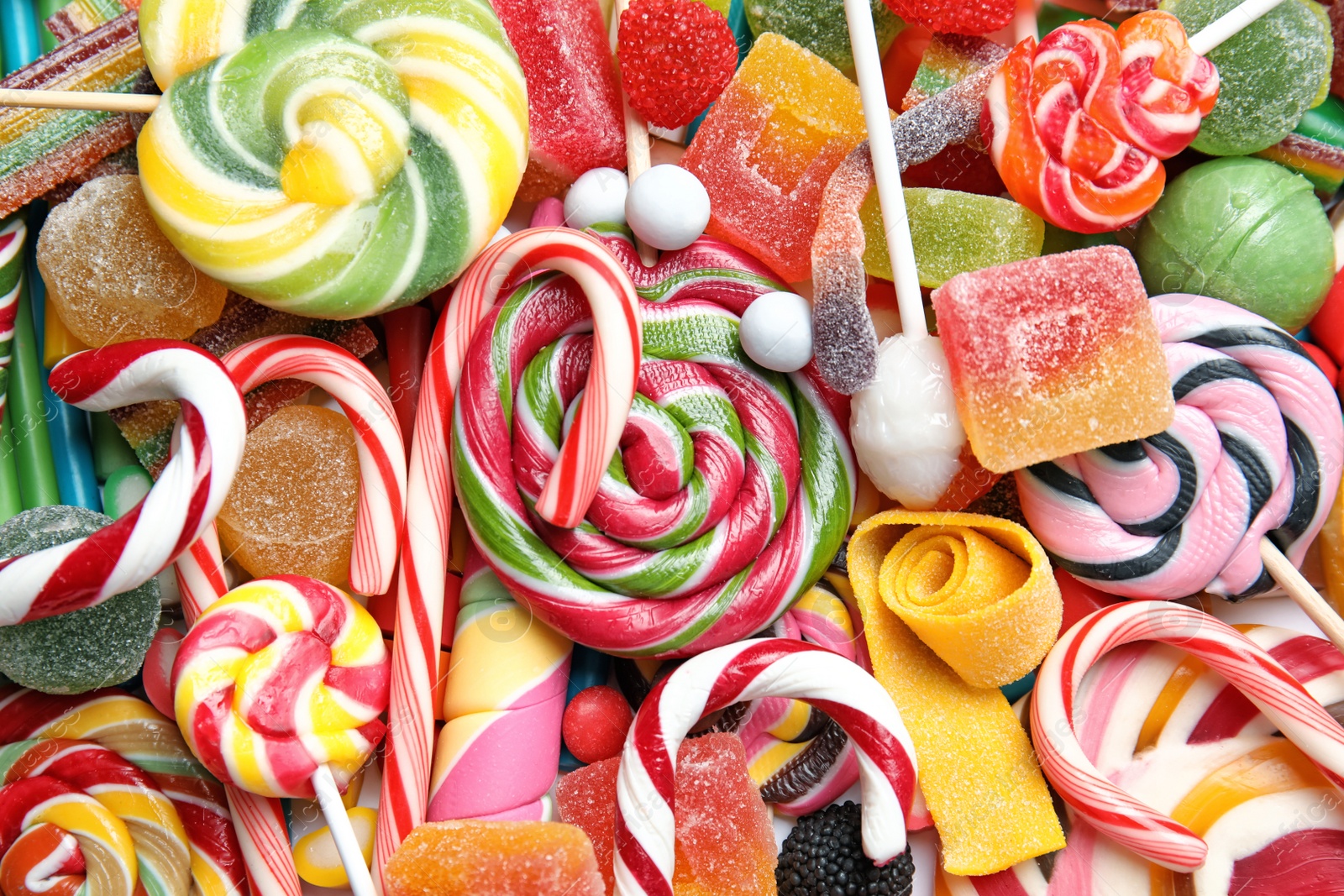 Photo of Many different yummy candies as background, top view