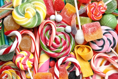 Many different yummy candies as background, top view