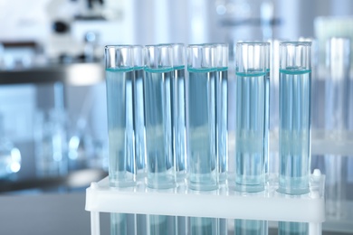 Test tubes with liquid on blurred background, closeup. Laboratory analysis