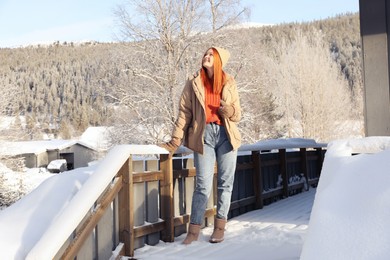 Happy young woman on terrace outdoors. Winter vacation