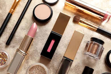 Photo of Different luxury makeup products on gold background, flat lay