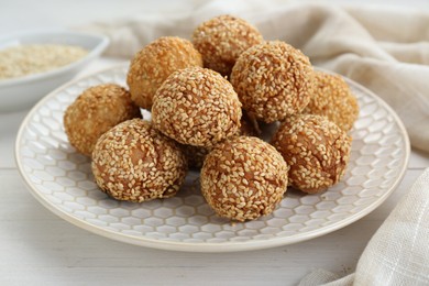 Photo of Delicious sesame balls on white wooden table, closeup