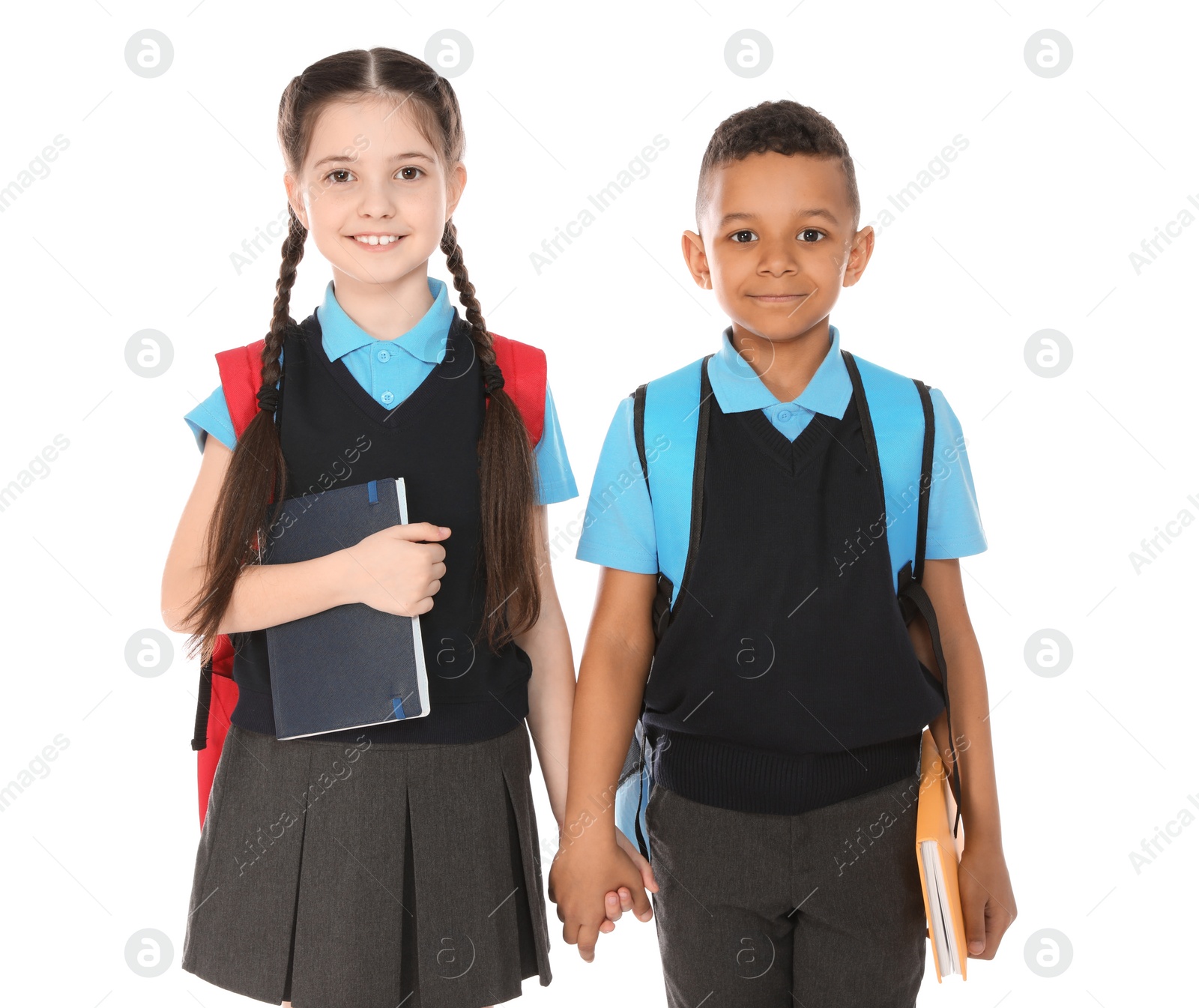 Photo of Portrait of cute children in school uniform with books on white background