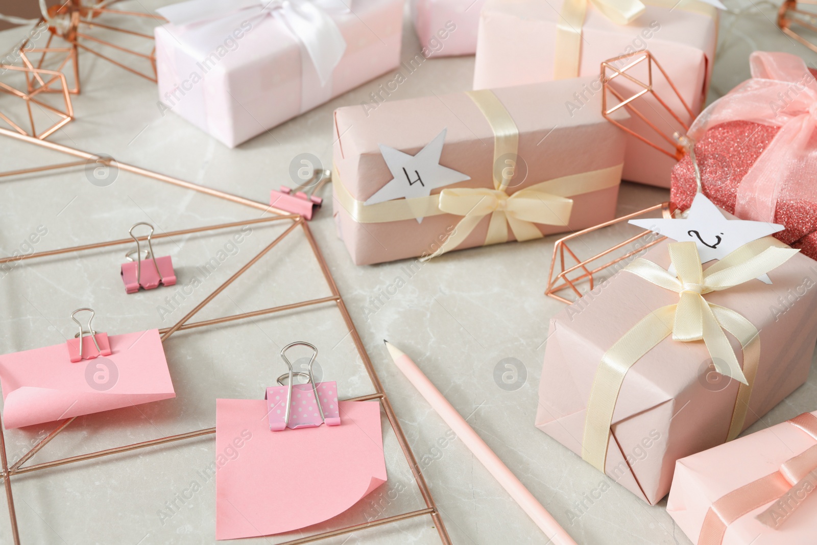 Photo of Gift boxes and paper notes on grey marble table. Creating advent calendar