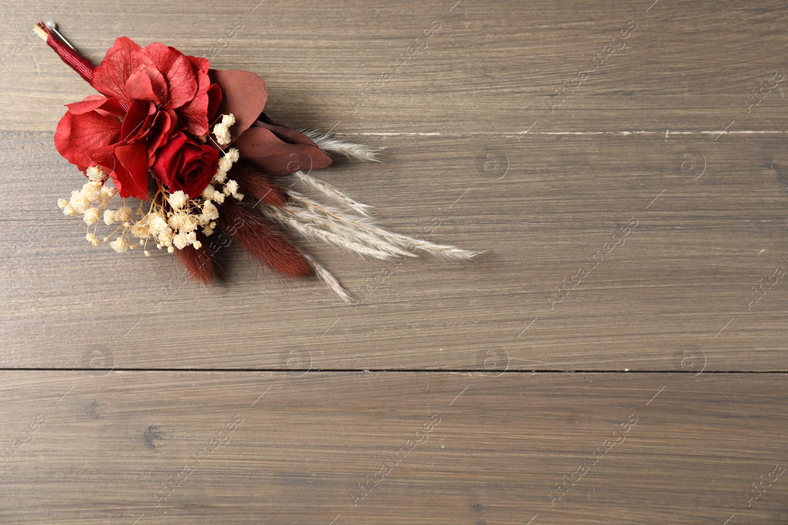 Photo of Beautiful boutonniere on wooden background, top view. Space for text