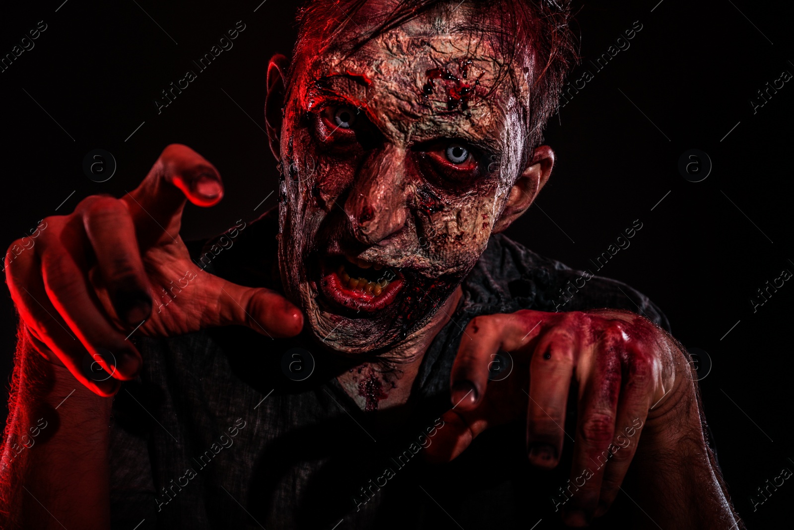 Photo of Scary zombie on dark background. Halloween monster