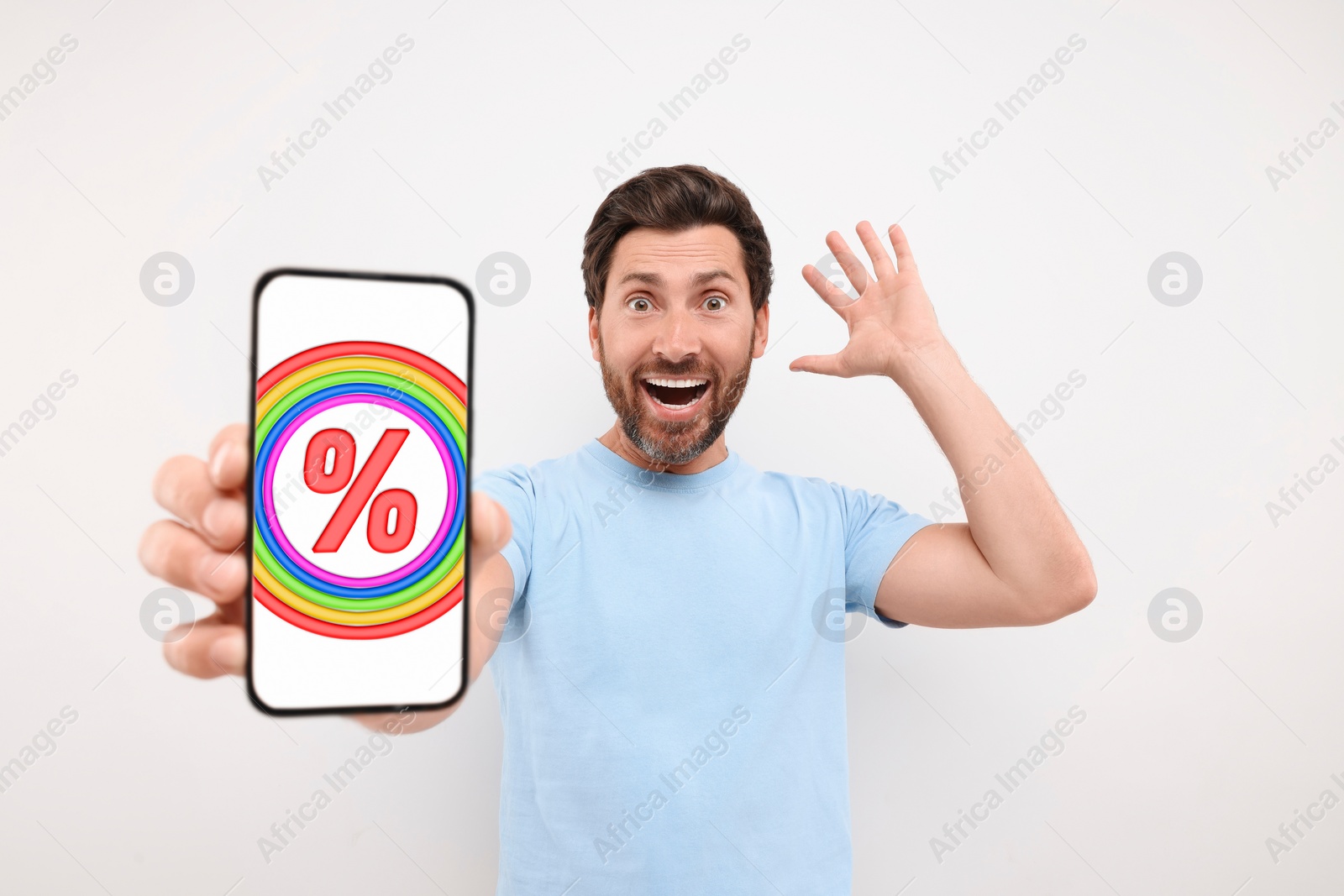 Image of Discount, offer, sale. Emotional man showing mobile phone with percent sign on screen, white background