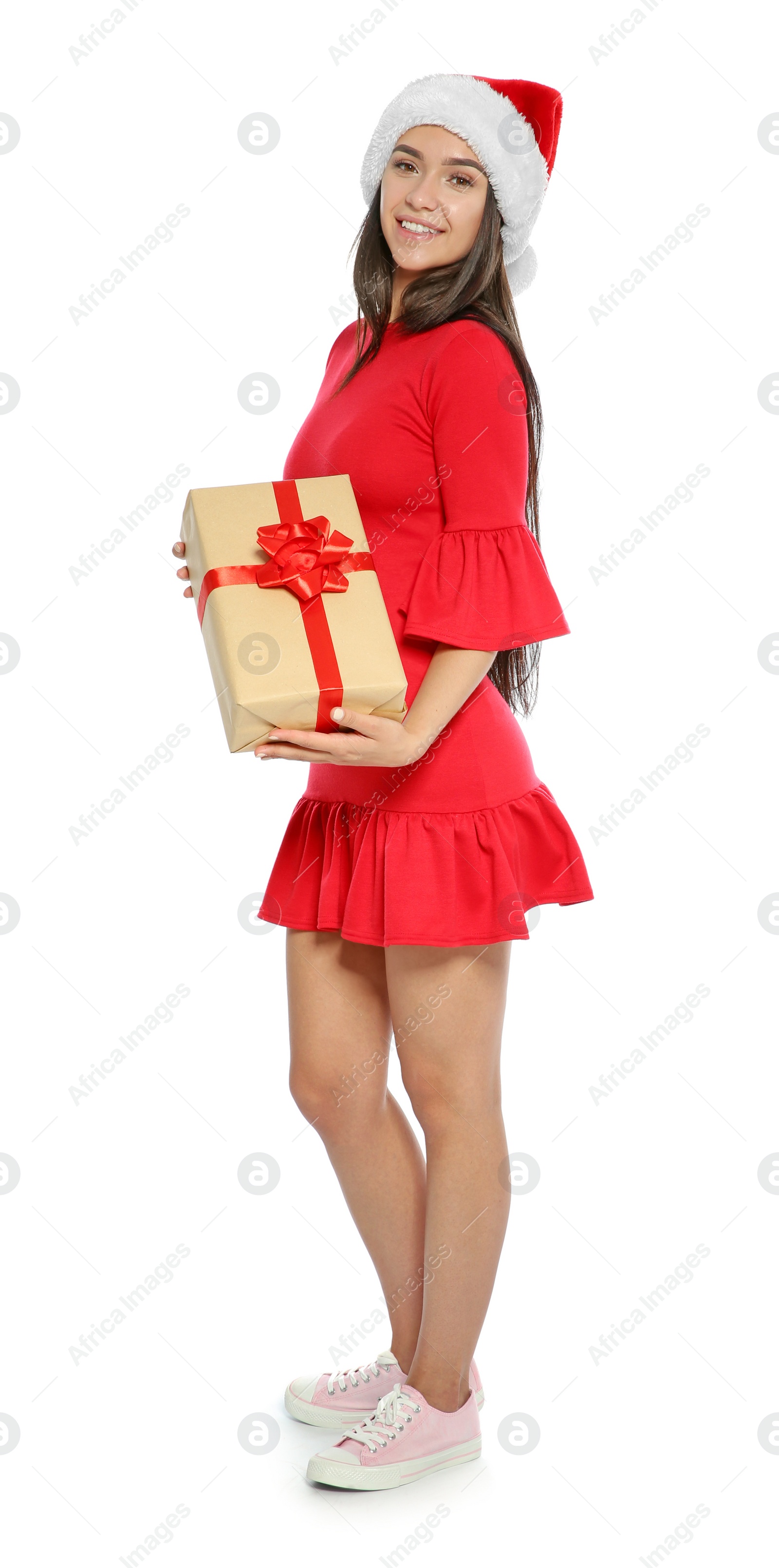 Photo of Young happy woman with Santa hat and gift box on white background. Christmas celebration