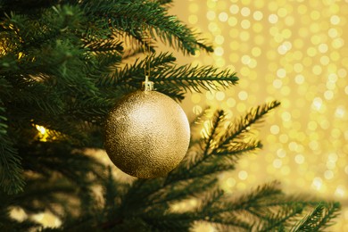 Photo of Closeup of shiny bauble hanging on Christmas tree indoors