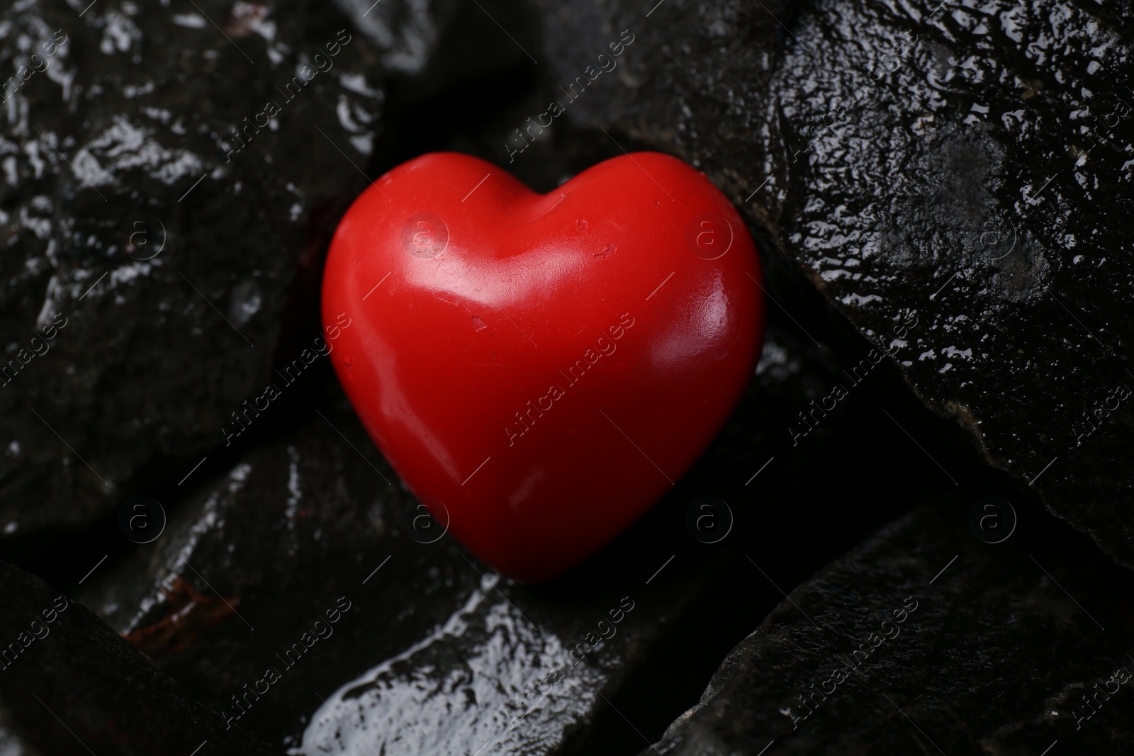 Photo of Red decorative heart on stones, closeup view