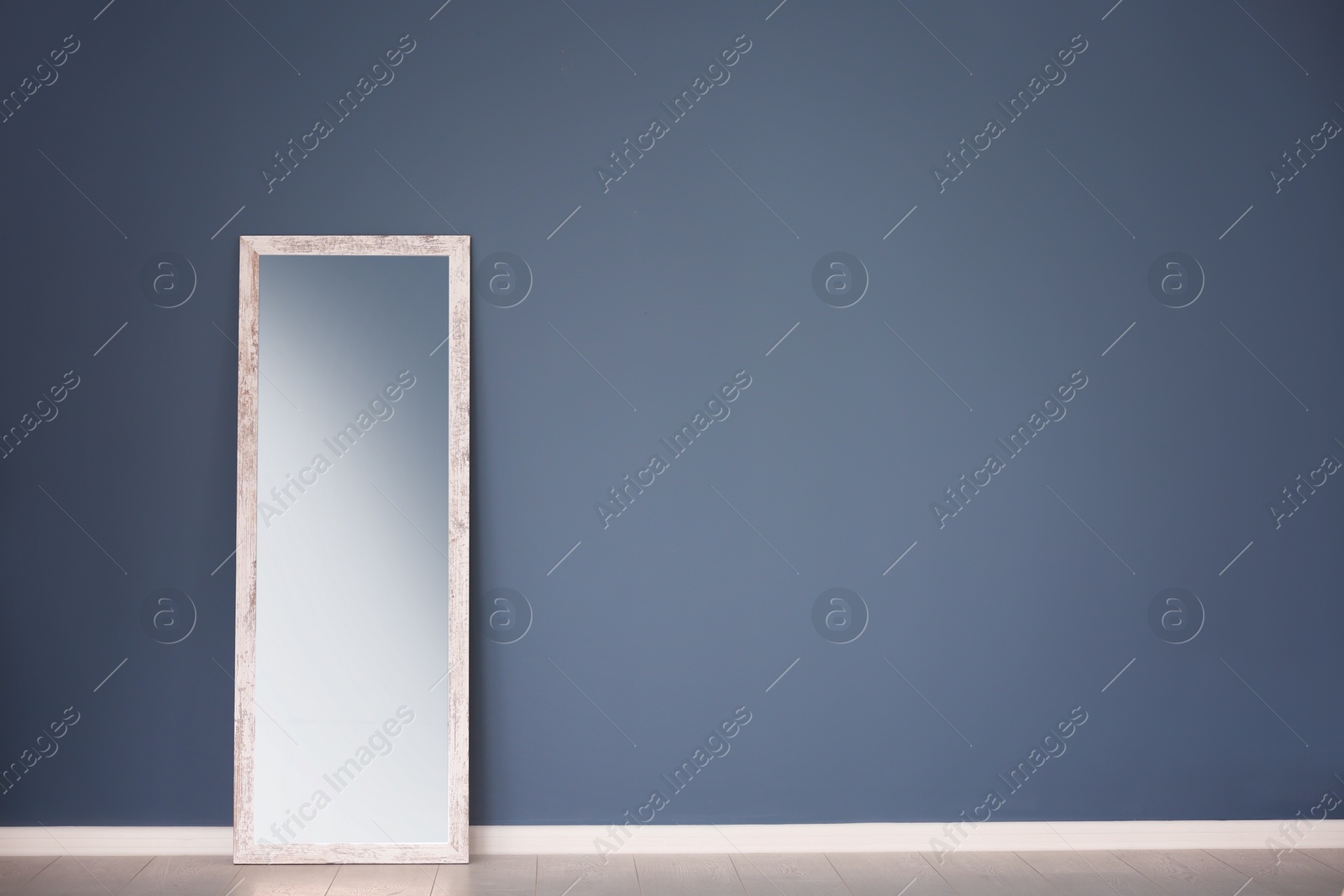 Photo of Large stylish mirror in empty room