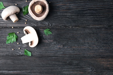 Photo of Flat lay composition with fresh champignon mushrooms on wooden background, space for text