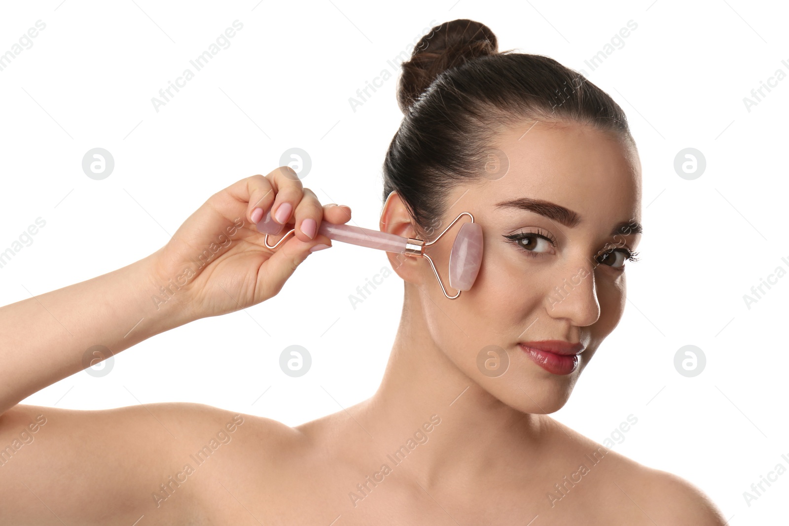 Photo of Woman using natural pink quartz face roller on white background