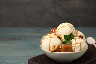 Photo of Delicious ice cream with caramel, popcorn and sauce served on table. Space for text