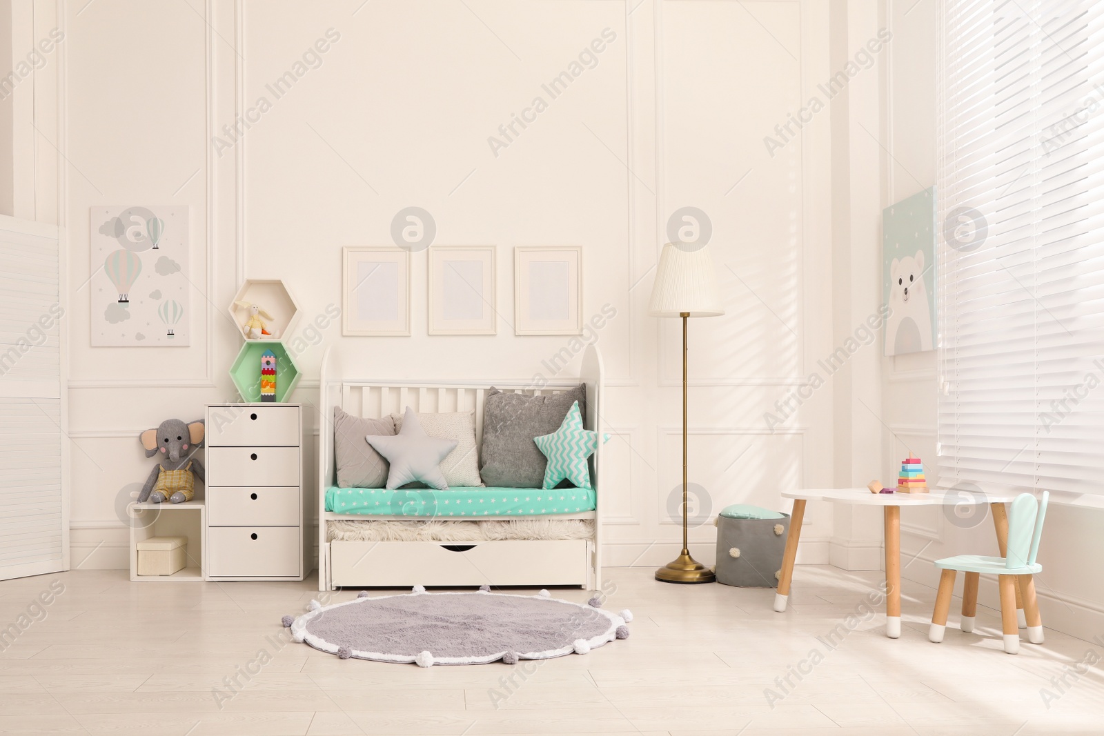 Photo of Cozy baby room interior with crib and toys