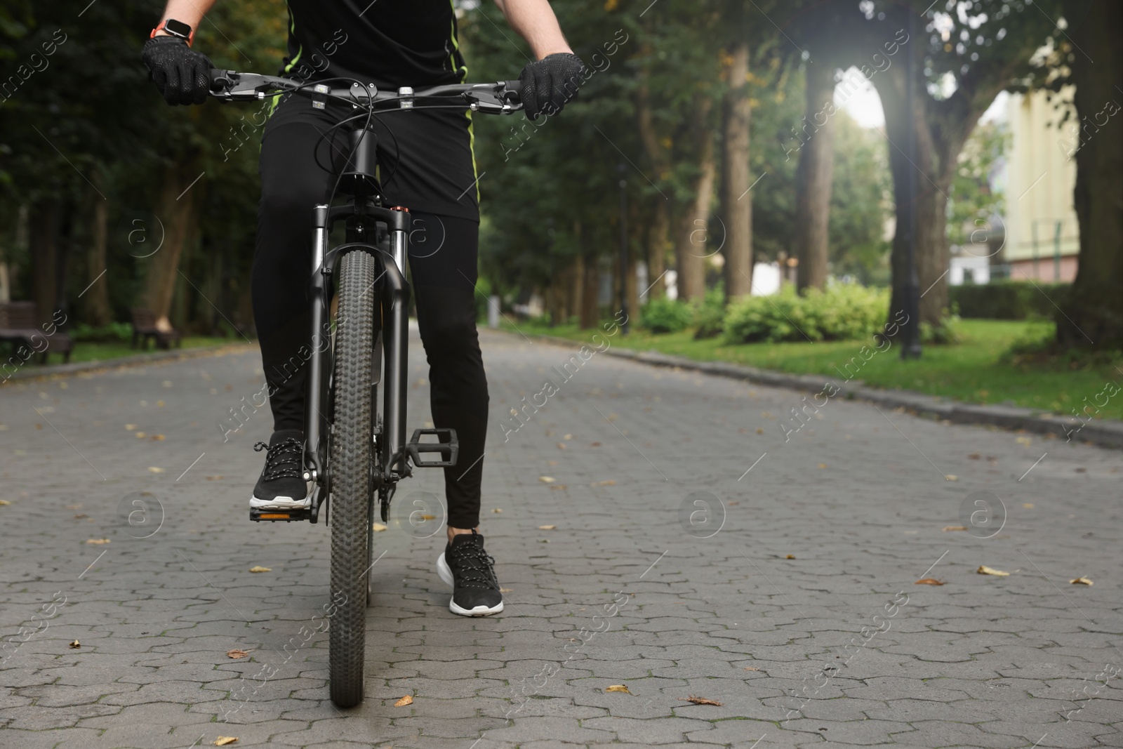 Photo of Man riding bicycle on road outdoors, closeup. Space for text