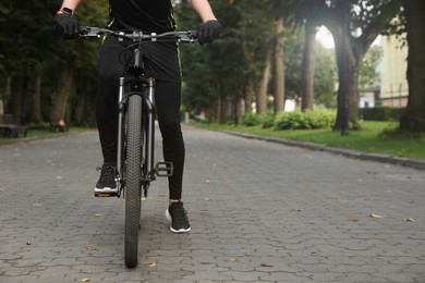 Photo of Man riding bicycle on road outdoors, closeup. Space for text