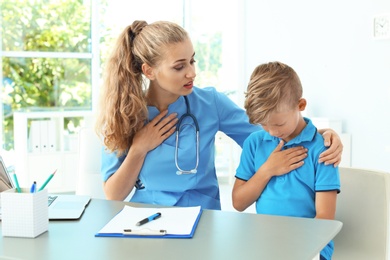 Female medical assistant consulting child in clinic