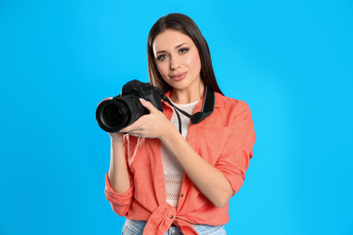 Photo of Professional photographer working on light blue background in studio