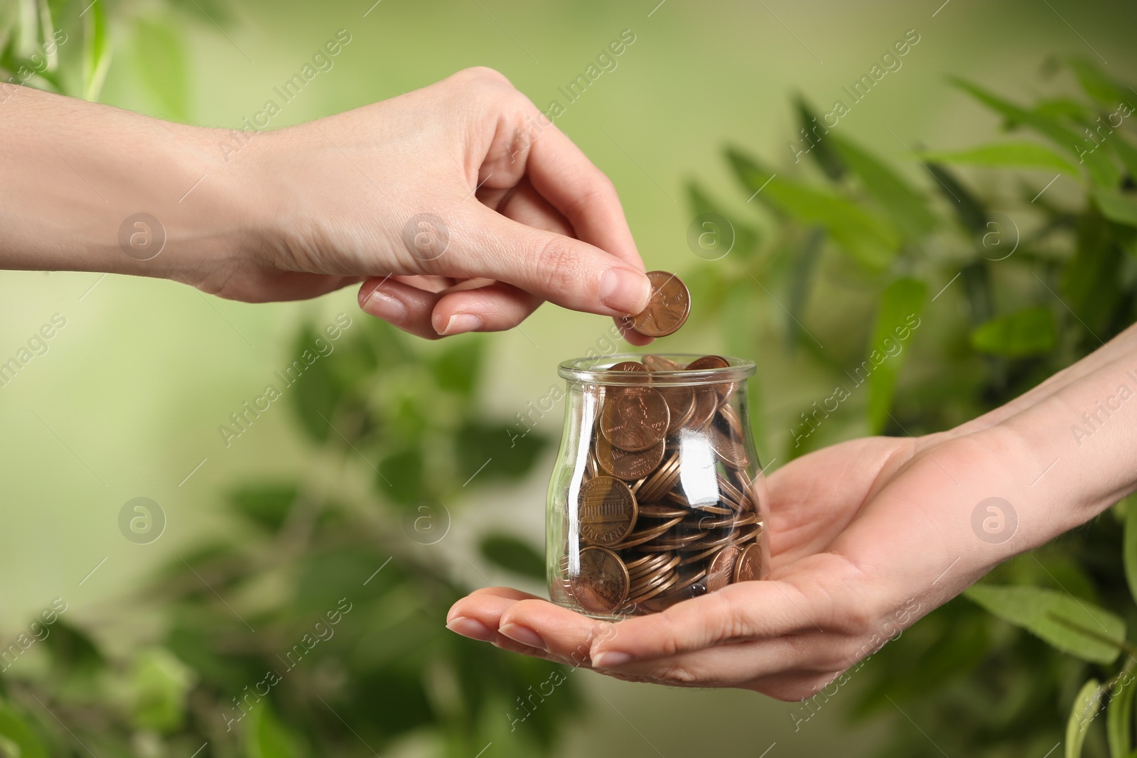 Photo of Woman giving coin to other person on blurred background, closeup. Money transfer