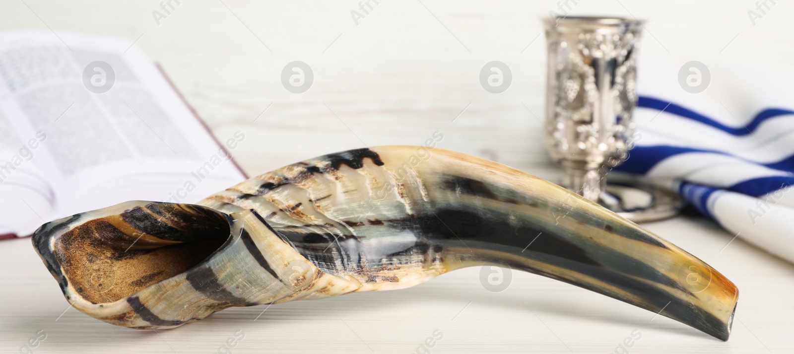 Image of Shofar and other Rosh Hashanah holiday attributes on white wooden table, banner design