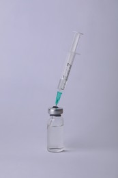 Disposable syringe with needle and vial on white background