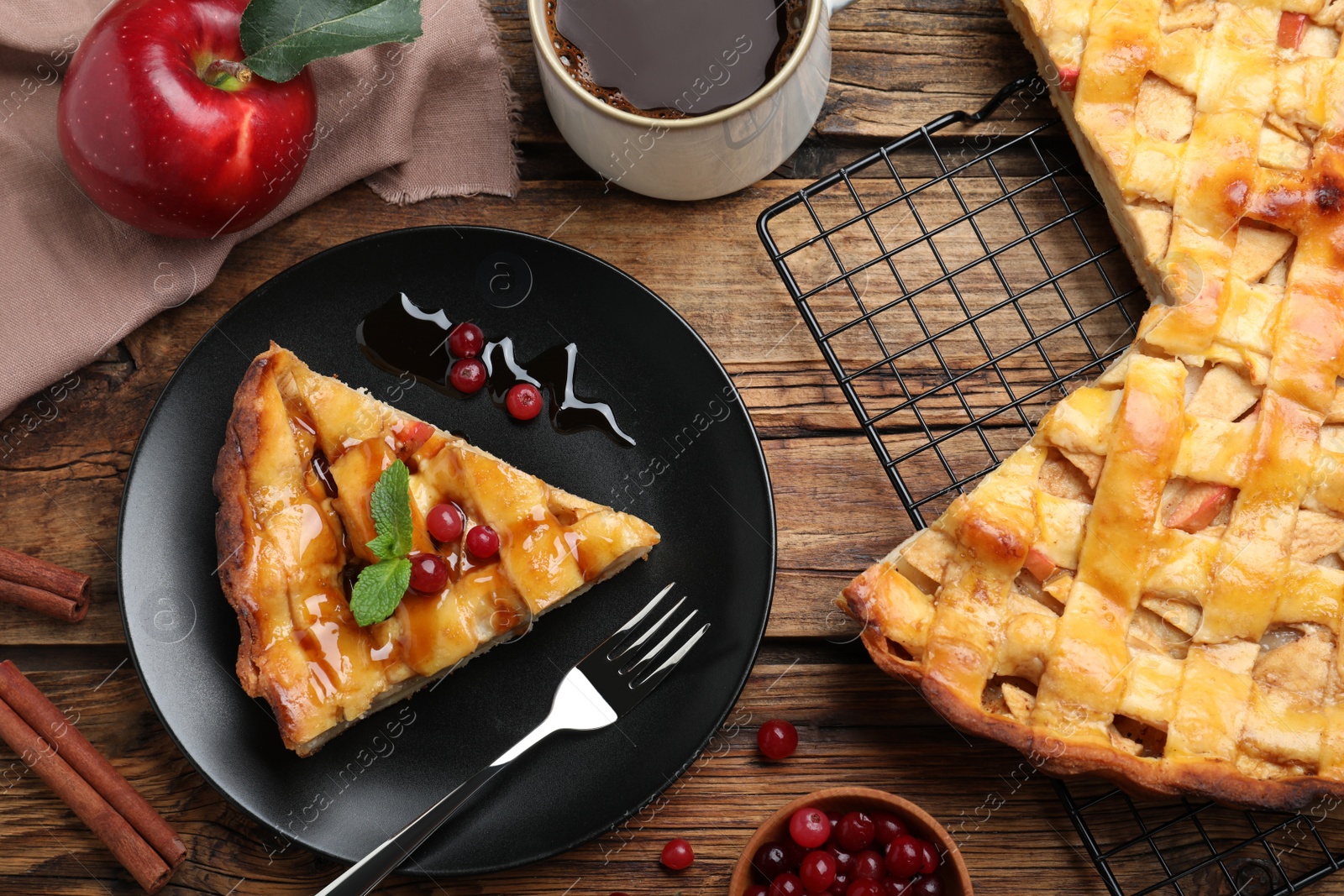 Photo of Slice of traditional apple pie with berries served on wooden table, flat lay