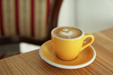 Cup of delicious coffee on wooden table indoors