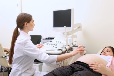 Photo of Young pregnant woman undergoing ultrasound scan in clinic