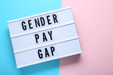 Lightbox with words Gender Pay Gap on color background, top view. Space for text