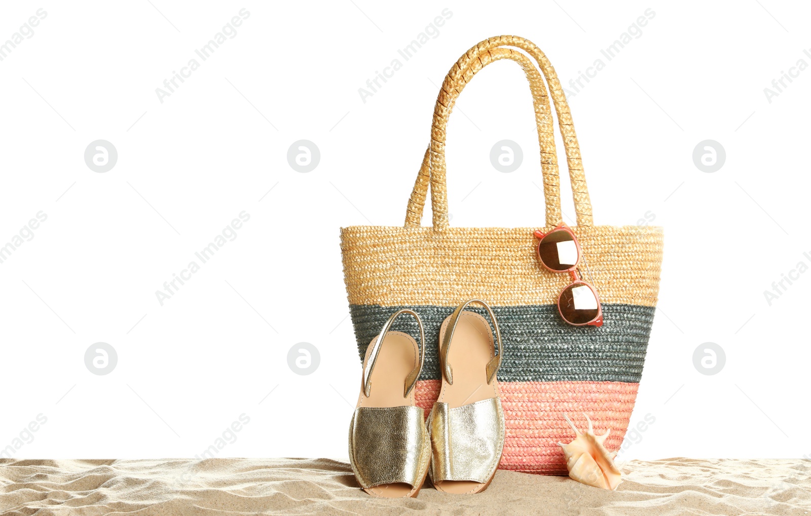 Photo of Wicker bag and beach accessories on sand against white background, space for text