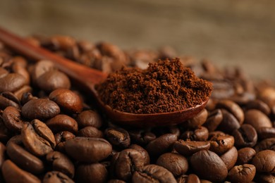 Photo of Spoon of ground coffee on roasted beans, closeup