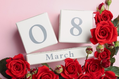 Photo of Wooden block calendar with date 8th of March and roses on pink background, flat lay. International Women's Day