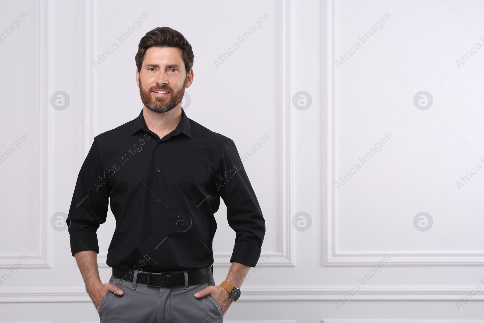 Photo of Portrait of handsome man near white wall, space for text