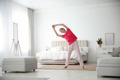 Photo of Young woman doing gymnastics at home. Morning fitness