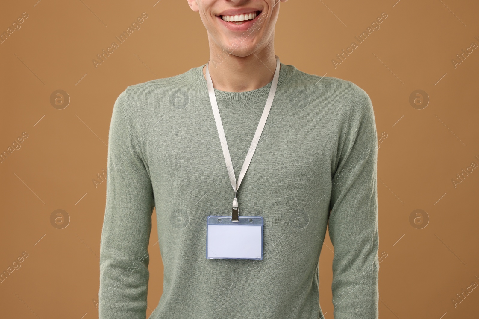 Photo of Man with blank badge on light brown background, closeup