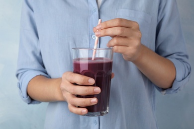 Photo of Woman with glass of fresh acai drink and straw, closeup