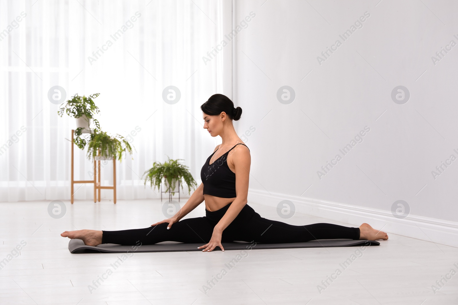 Photo of Professional young acrobat practicing yoga at home