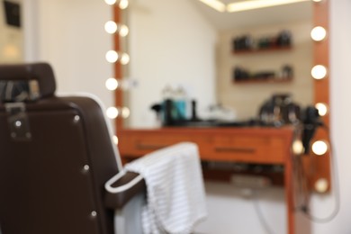 Photo of Blurred view of stylish barbershop interior with hairdresser workplace