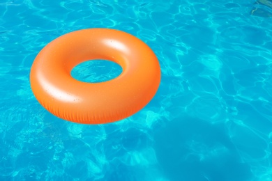 Photo of Inflatable ring floating in swimming pool on sunny day. Space for text